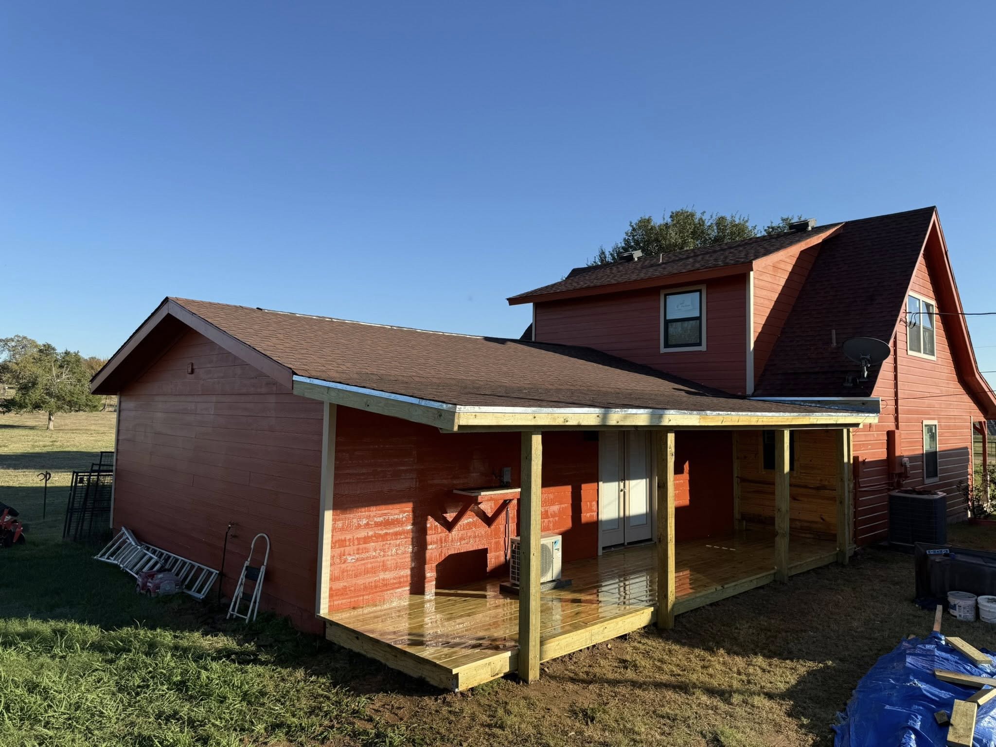 Wraparound porch build on a red farmhouse
