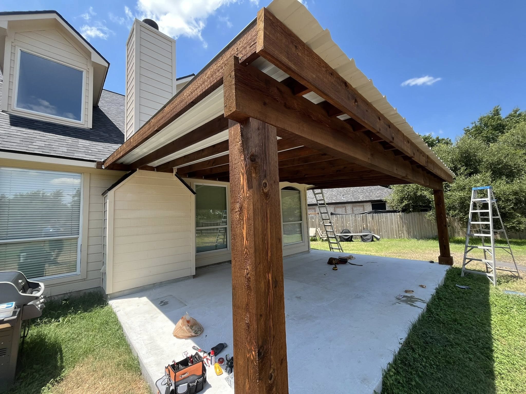 Stained cedar pergola attached to home