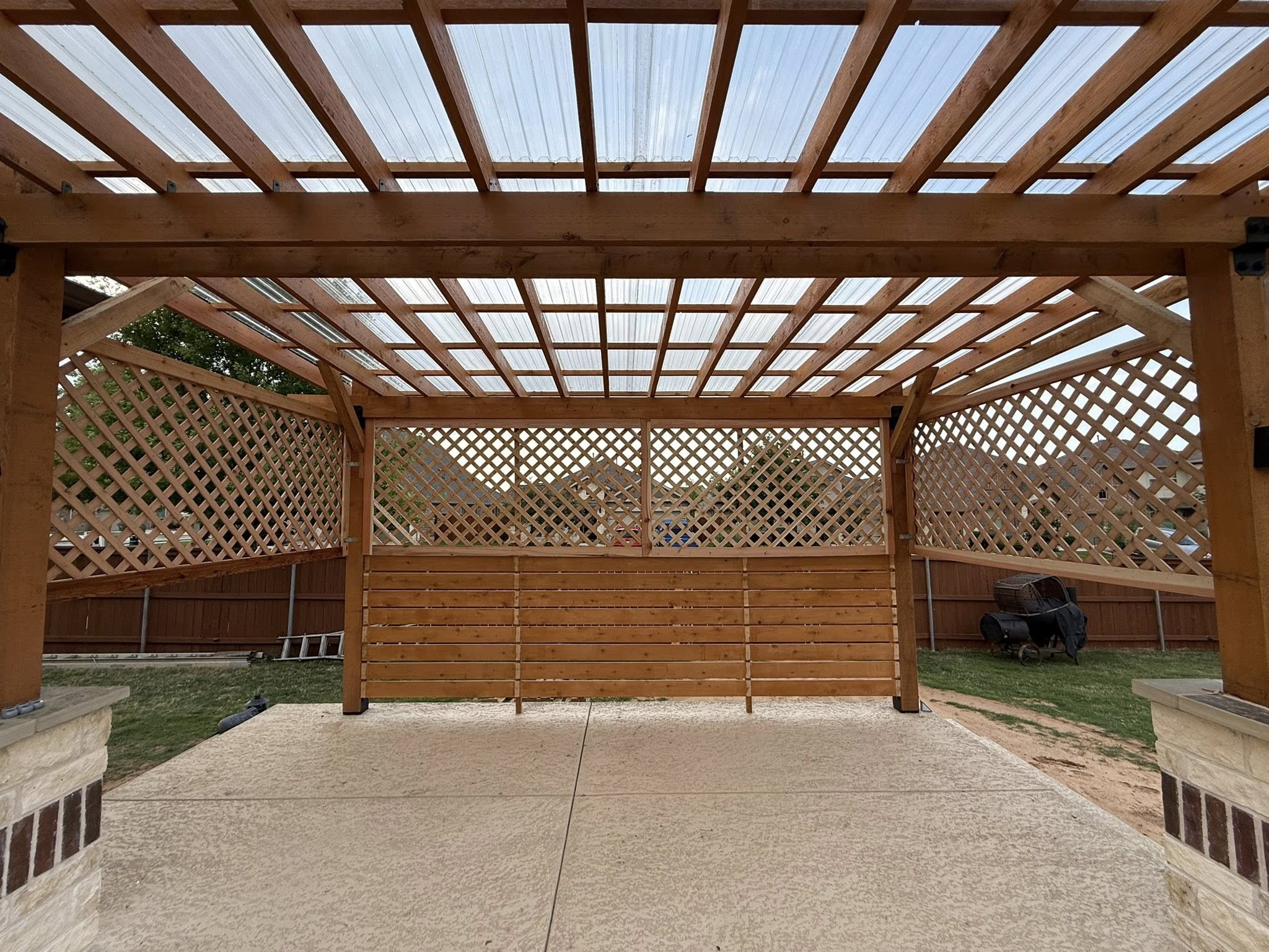 Cedar pergola with lattice walls and clear roof