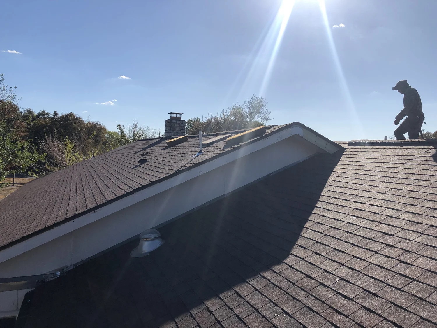 Worker on shingle roof replacement