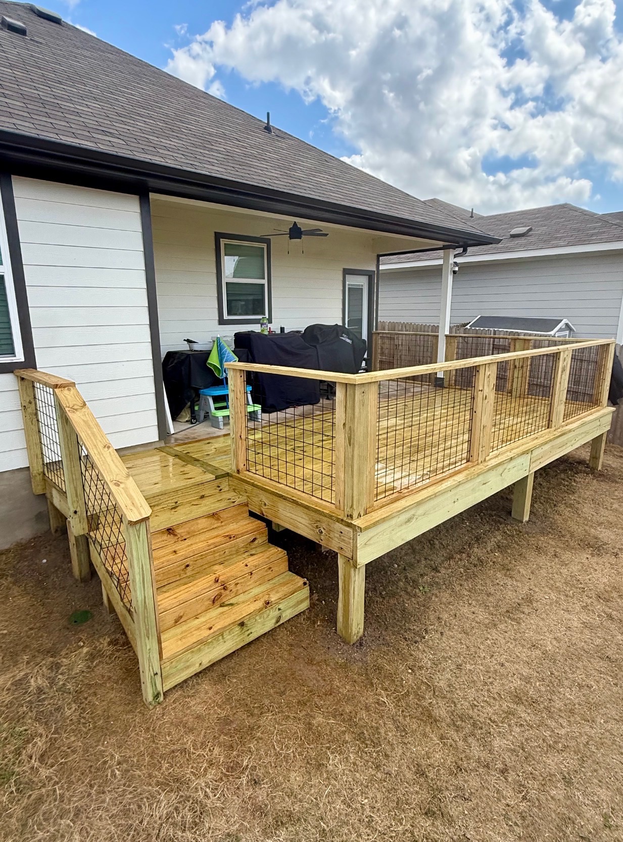 Custom cedar deck with cattle panel railings, built for a Buda, TX home.