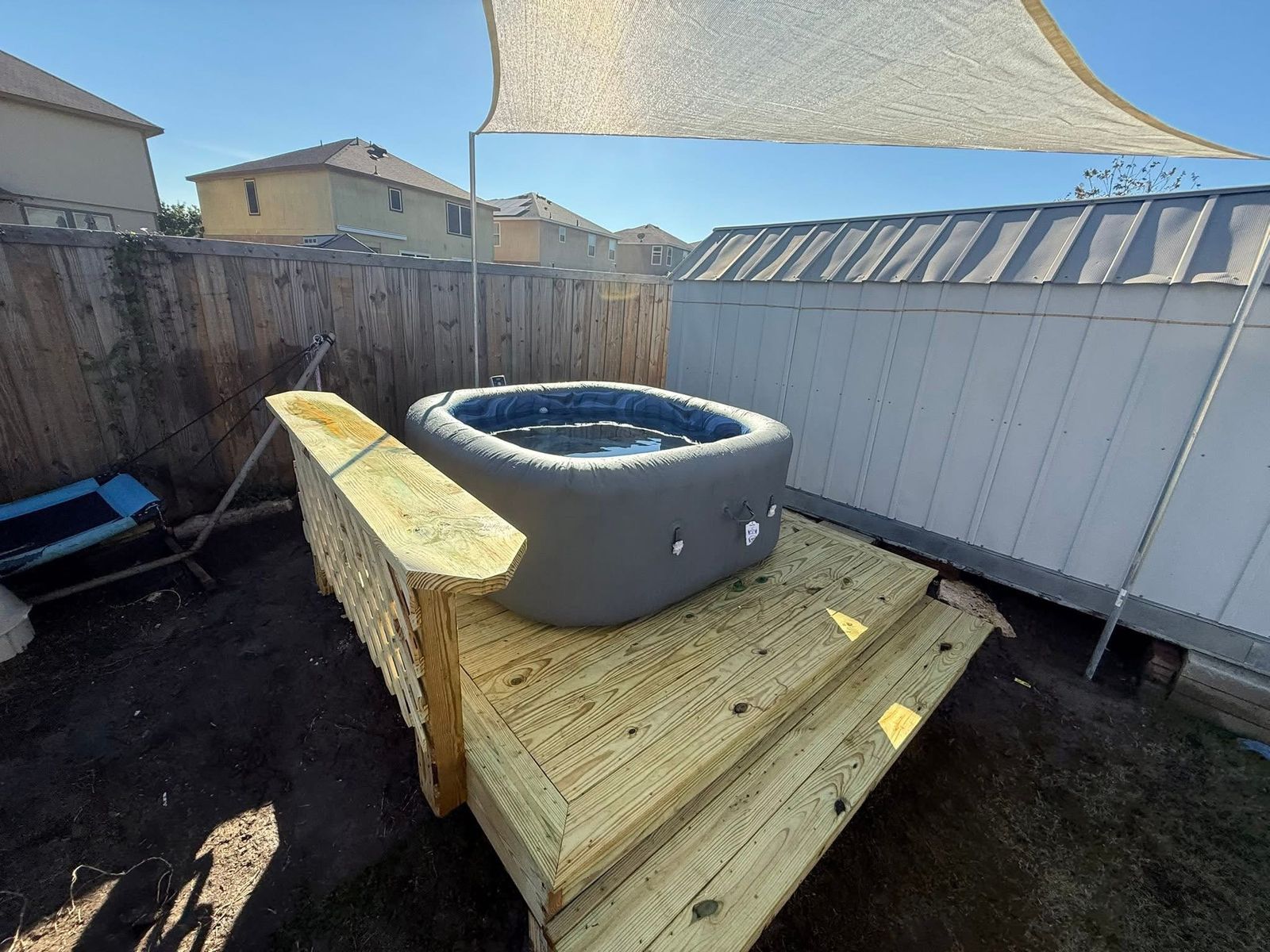 Pressure-treated hot tub deck with a step, lattice privacy wall and bench cap in an Austin, TX backyard