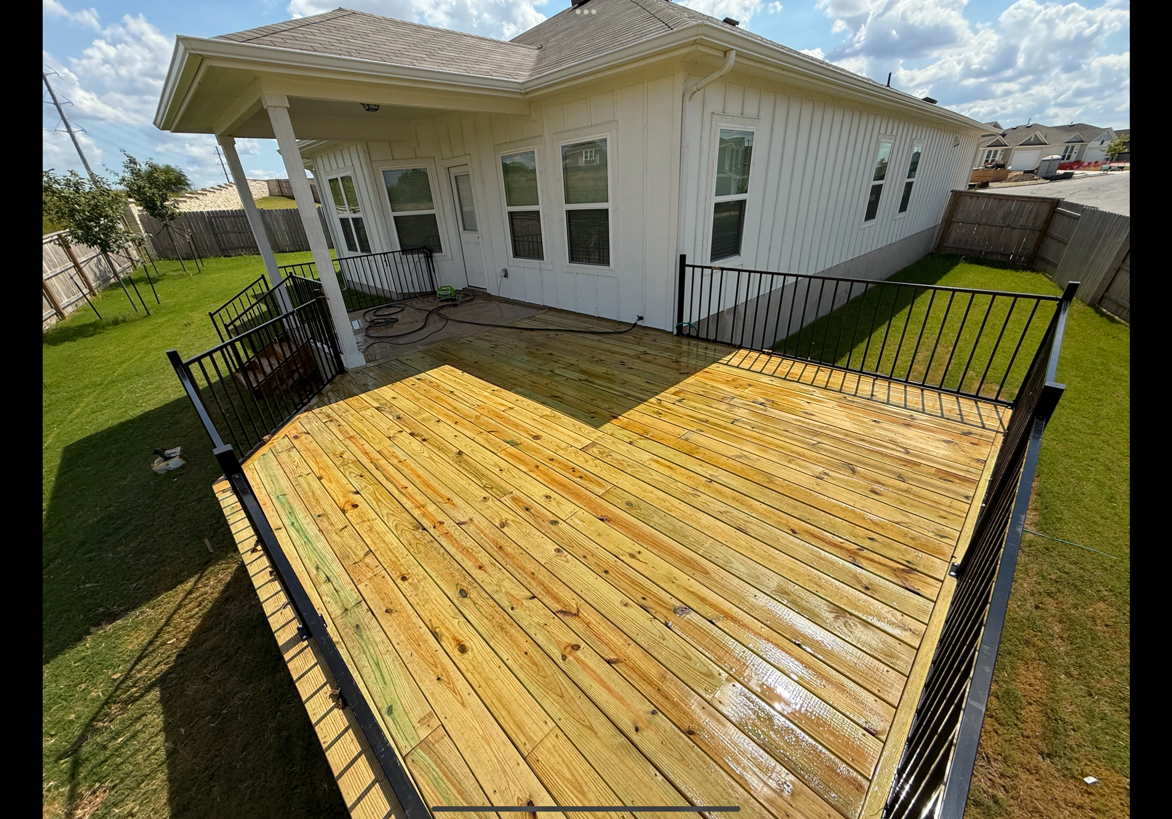 Pressure-treated backyard deck with metal railings, Austin TX