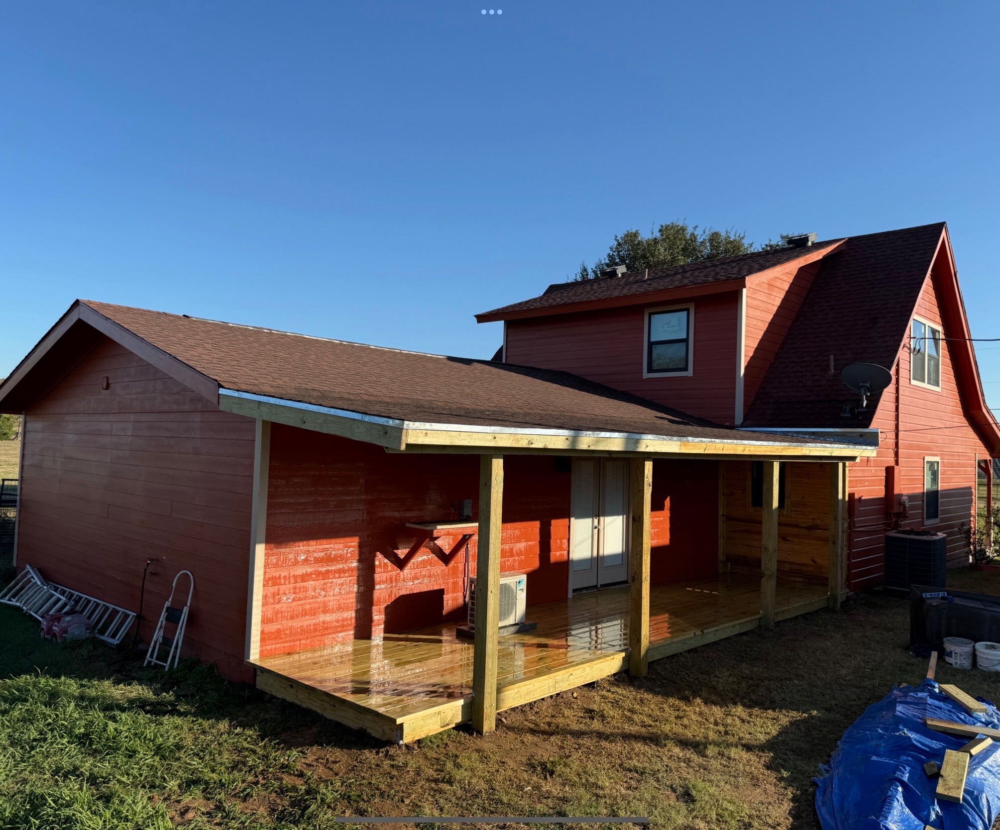 Wraparound porch build on a red Texas farmhouse