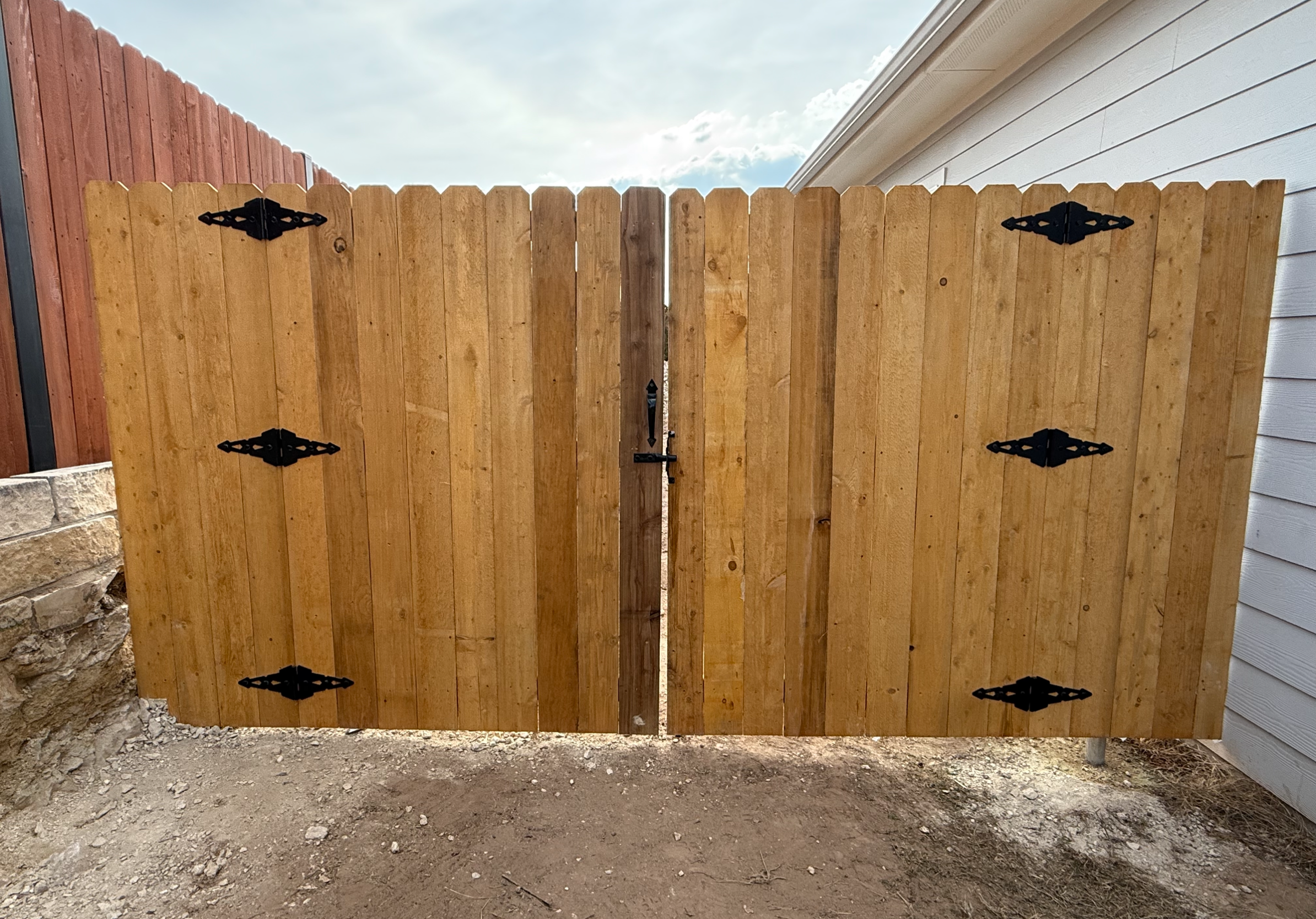 Custom cedar double drive gate with decorative hinges, Austin TX
