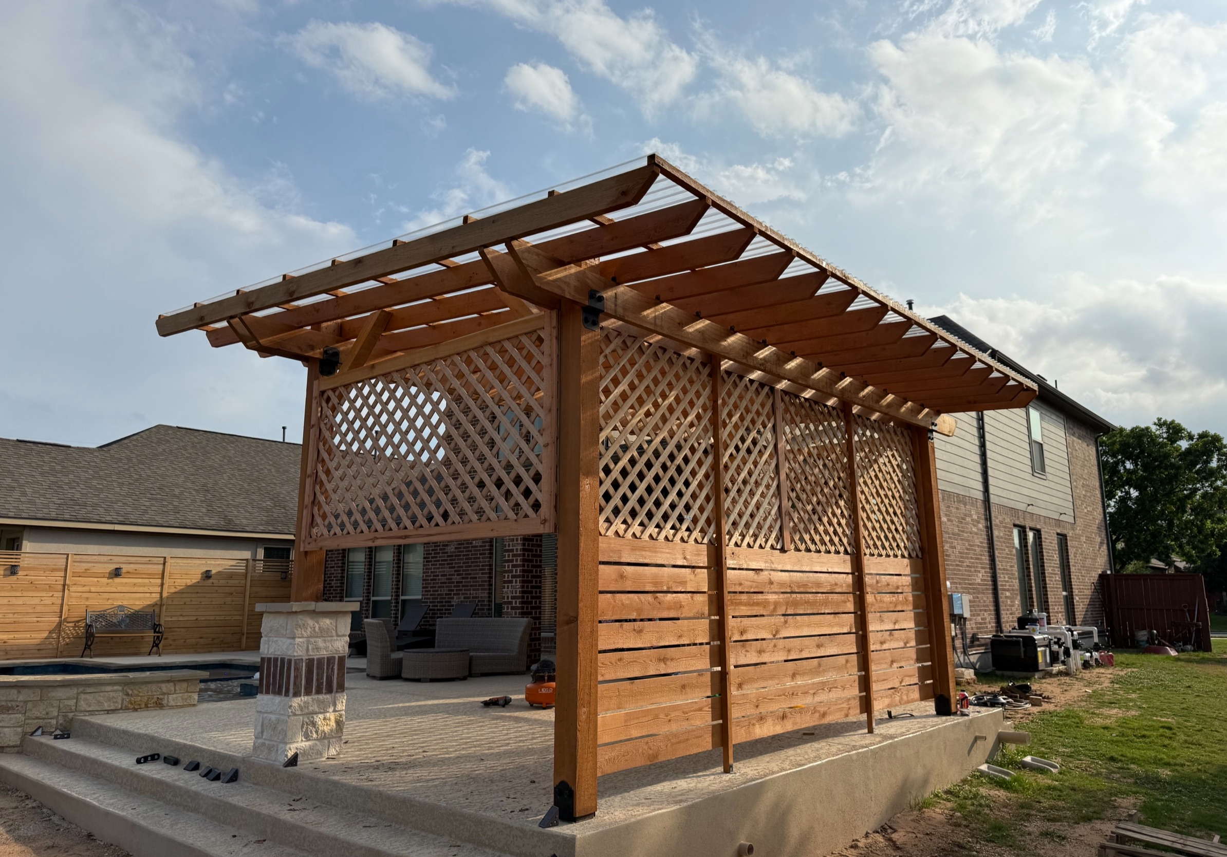 Custom cedar pavilion with lattice walls in the evening, Austin TX