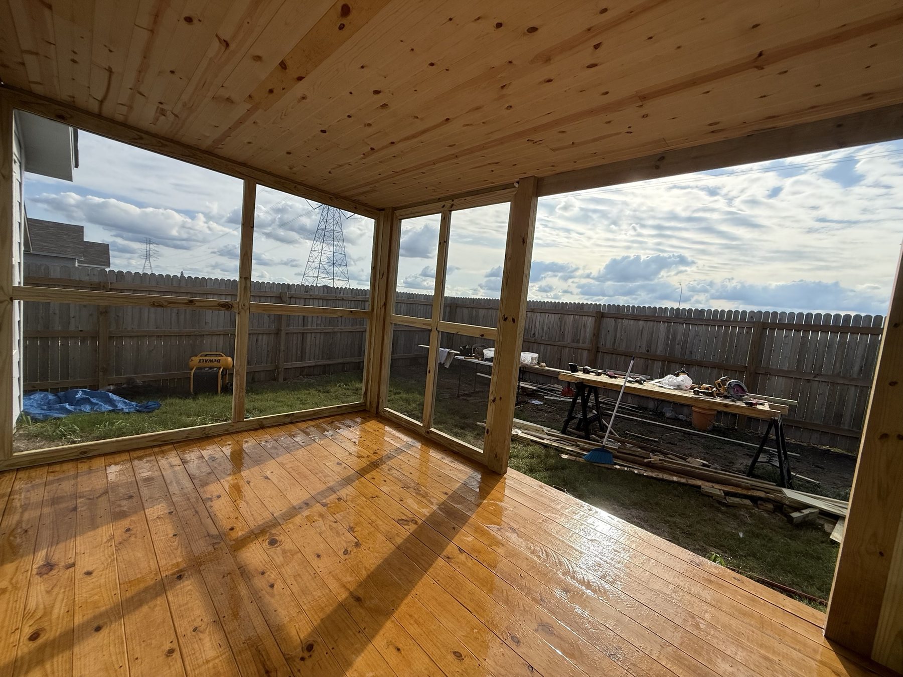 Screened porch with tongue-and-groove pine ceiling and stained pine floor, built in greater Austin by JB Contracting ATX.